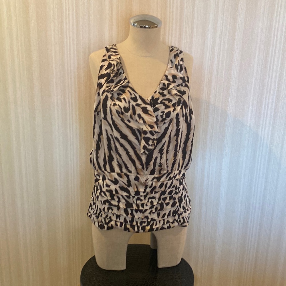 Sleeveless, ruffle front, pleated bottom, elastic back bottom.